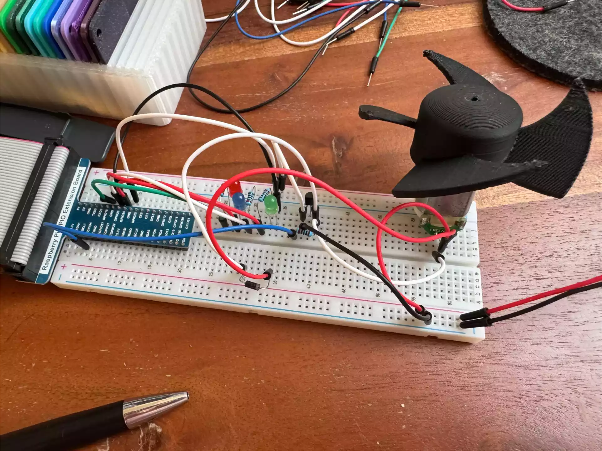 A breadboard with a GPIO extended board three RGB LEDs and one electric motor with a fan on top.
