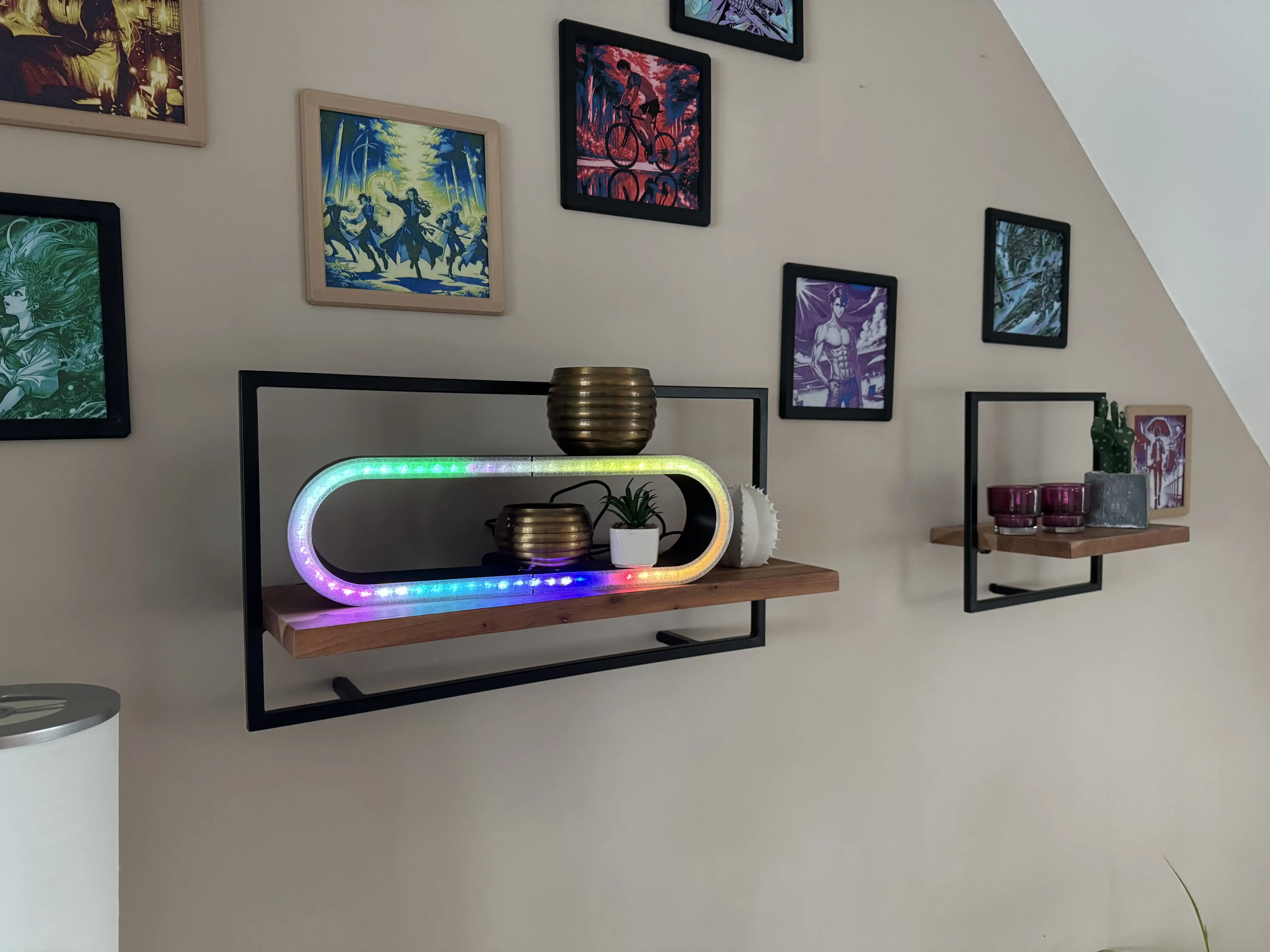 A background with a lot of 3D printed images. And one of my self 3D designed and printed ring light. what is more or less a square rectangle with rounded corners and in with a black shell and bright rainbow color lightning in front of a milky glass 3d printed window through  